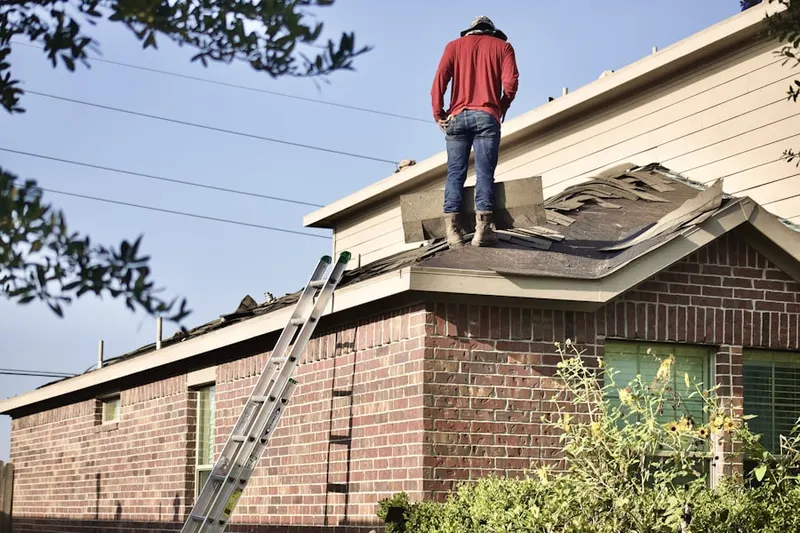 Professional roofer working on a residential roof in H and H Corner